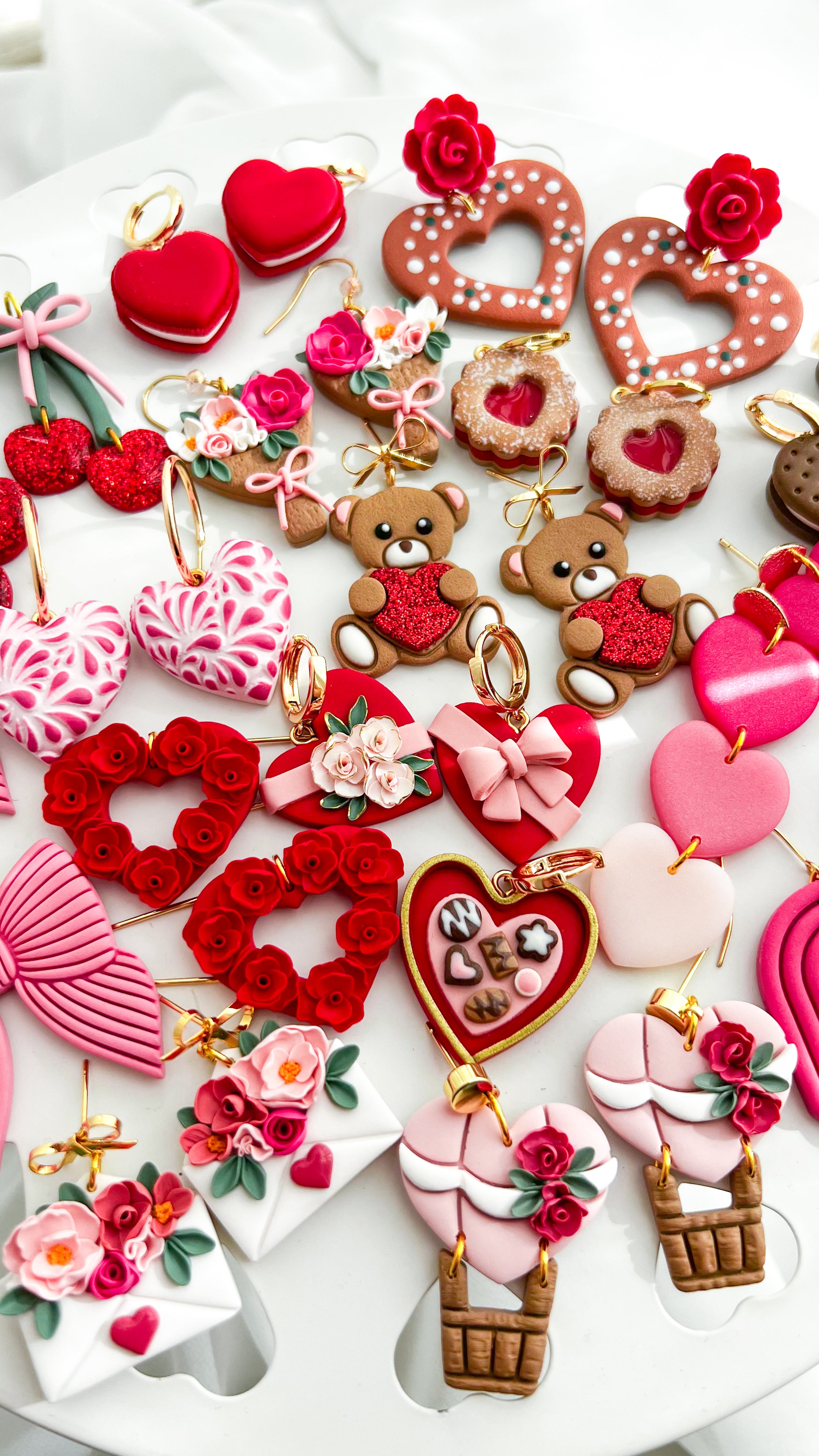 Collection of Valentine's Day-themed earrings on a white surface