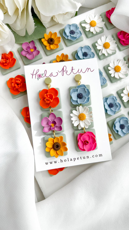 Floral earrings on a card with 'Hola Petun' branding, surrounded by flowers.
